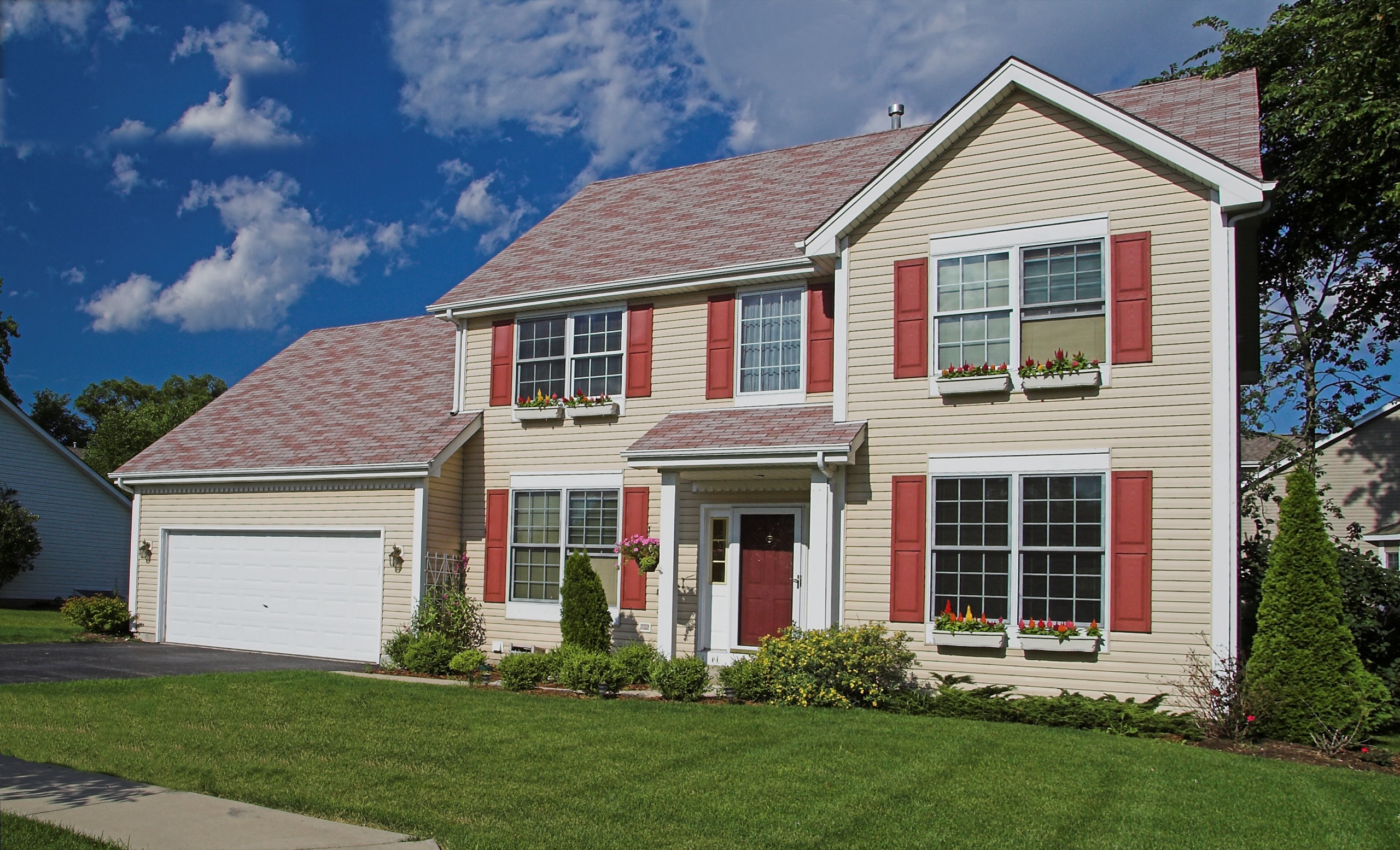 Completed two-story home with roofing, siding, windows, and landscaping