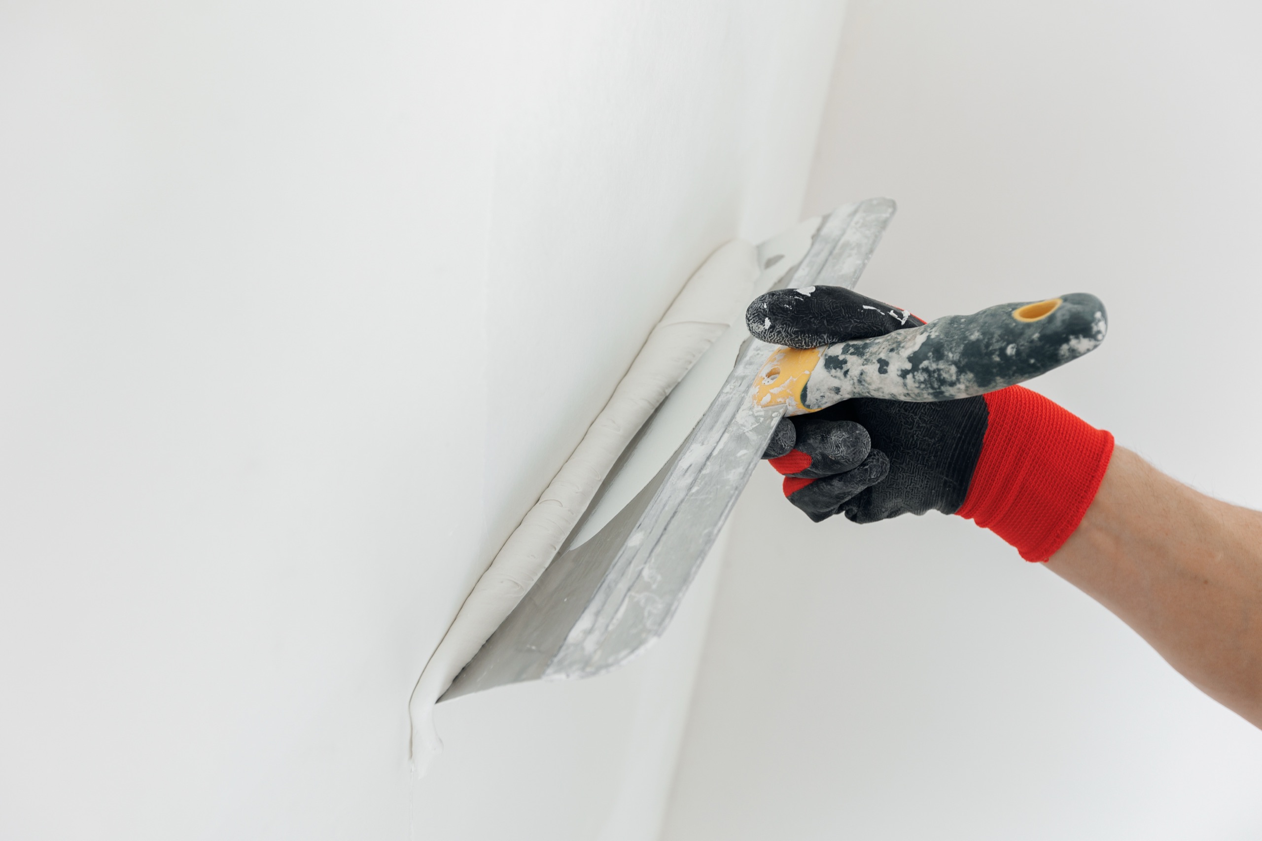 Craftsperson applying a smooth finish to a drywall joint