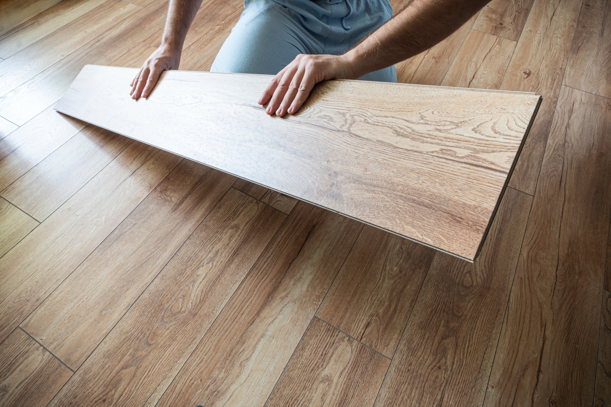 Craftsperson installing wood-look plank flooring