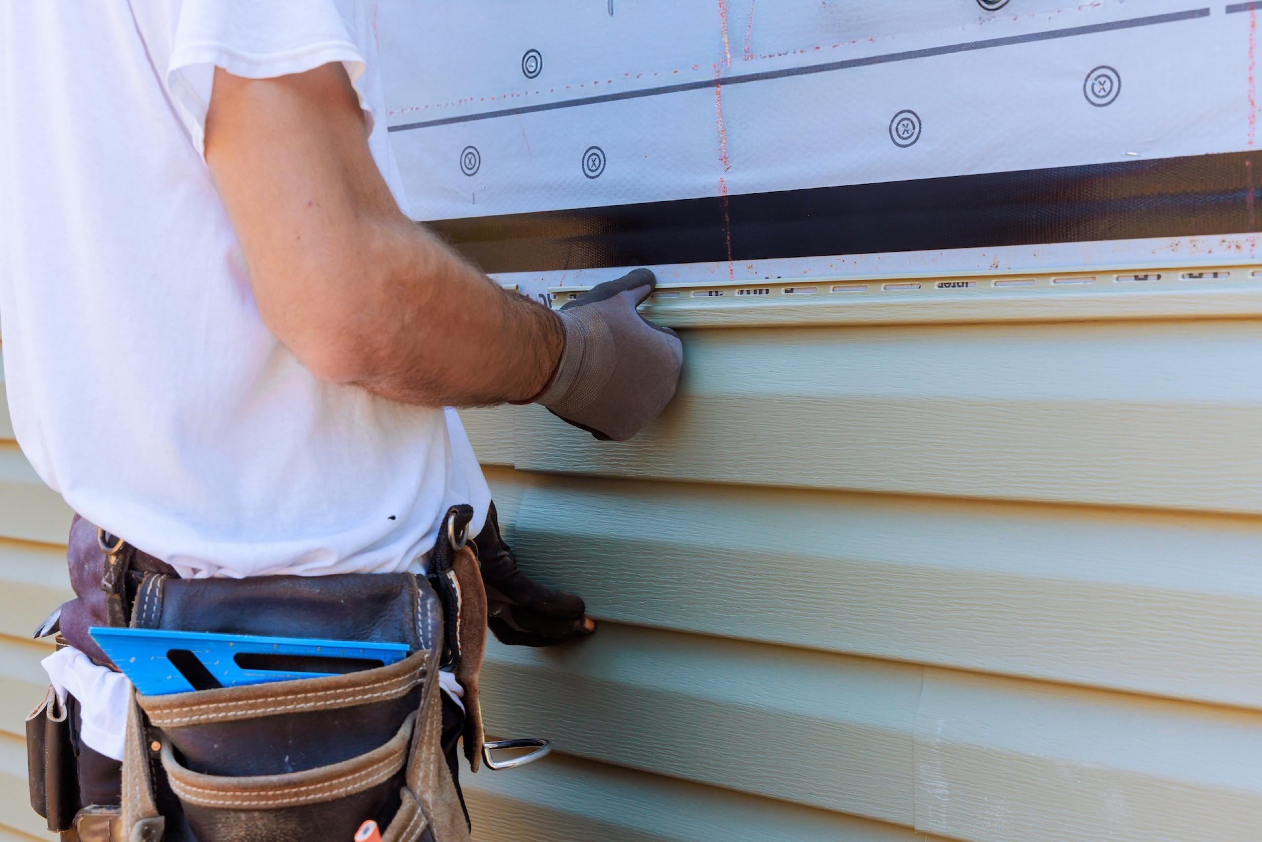 Craftsperson installing horizontal residential siding